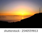 Pico do Arieiro, Madeira - An awe-inspiring sunrise casting golden hues across the sky and ocean, with the sun rising majestically on the horizon.