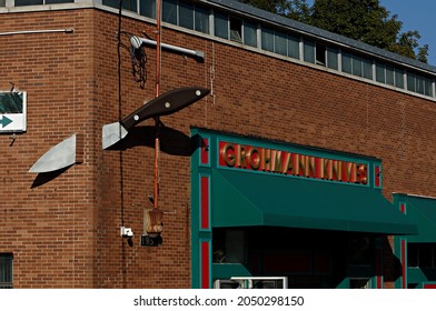 Pictou, NS, Canada- 09 24 2021: A Large Knife Going Through The Corner Of The Grohmann Knives Company Building In Pictou, Nova Scotia.  