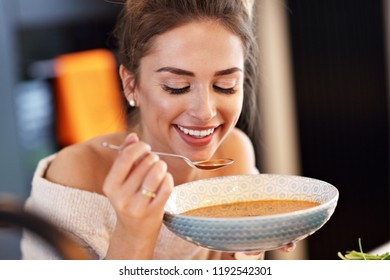 Picture Of Adult Woman Tasting Pumpkin Soup In The Kitchen