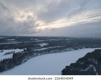 Picture of aerial view of sunset, frozen lakes, snowy forest, finland near rovaniemi