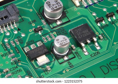 A picture of aluminium electrolytic capacitors, IC micom, volt detector and resistor on printed circuit board.