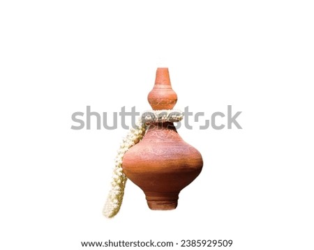 In the picture is an ancient water container made from clay that was molded and then fired to turn brown and a bunch of white jasmine flowers.