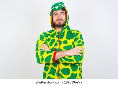 Picture of angry Young caucasian man wearing a pajama standing against white background looking camera.