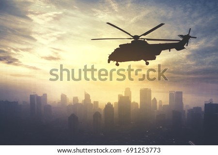 Picture of army helicopter flying over downtown, shot at sunrise time