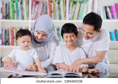 Picture Of Asian Family Sitting On The Couch While Reading Books Together In The Library