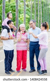 Picture Of Asian Three Generation Family Talking Each Other While Standing In The Park