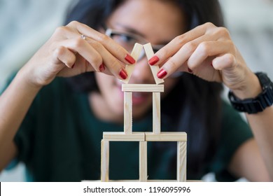 Picture Of Asian Woman Is Building A House Of Wooden Blocks