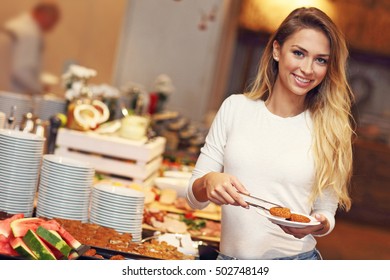 Picture of attractive woman at breakfast buffet in hotel