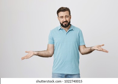 Picture Of Bearded Handsome Man Looking Questioned Standing With Spread Hands Over White Background. Middle Aged Guy Do Not Know What Everyone Want From Him So He Lifts His Arms And Askes Straight.