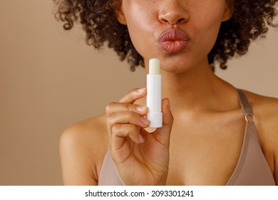 Picture of beautiful woman with lip balm, indoors