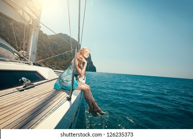picture of beautiful young woman sitting on the yacht
