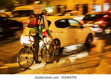 Picture Of A Bicycle Messenger In City Traffic At Night