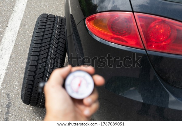 Picture of black car\'s brand new tyre on the road on\
a summer day