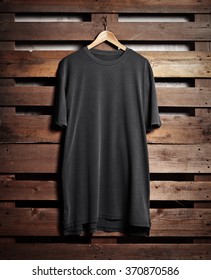 Picture Of Black Tshirt Hanging On Wood Background