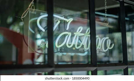 Picture Of A Blue Tattoo Light Sign On A Window From A Tattoo Studio