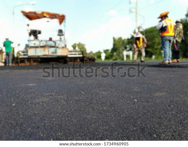Picture blurred asphalt road construction By\
using heavy machinery