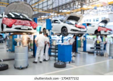 The Picture Is Blurry While The Mechanic Works In The Car Service Center. There Are Cars. Many Customers Come To Use The Oil Change Service.