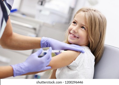 Picture of brave little girl receiving injection or vaccine with a smile