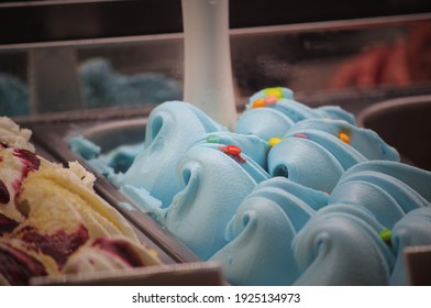 A Picture Of A Bubblegum Blue Ice Cream With Candy On Top Of It.