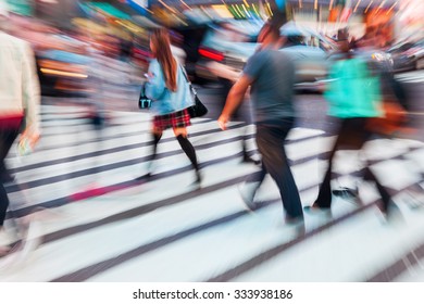 picture with camera made motion blur effect of people crossing a street in a big city
