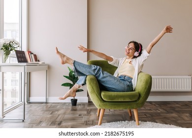 Picture of caucasian brunette woman having fun at home . Dark-haired young girl in headphones listening music sitting on the chair. Home mood, lifestyle  - Shutterstock ID 2182675195