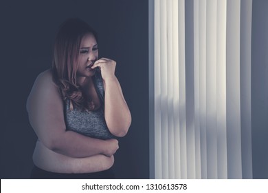 Picture Of Caucasian Fat Woman Looks Sad While Standing Near The Window