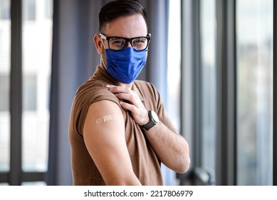 Picture Of Cheerful Adult Man With Mask, With A Band Aid On His Shoulder Skin.