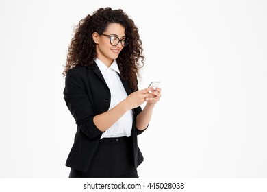 Picture Of Cheerful Curly Business Girl Wearing Glasses Looking At Phone Over White Background