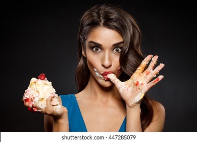 Picture Of Cheerful Girl In Blue Dress Eating  Piece Of Cake