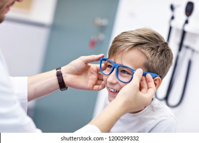 Picture Of Child Optometry Male Optometrist Optician Doctor Examines Eyesight Of Little Boy