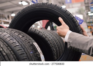 Picture closeup on hands choosing a tire or tyre - Shutterstock ID 277500833