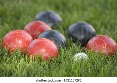 A Picture Of Colourful Bocce Balls On The Lawn Under The Sunlight With A Blurry Background