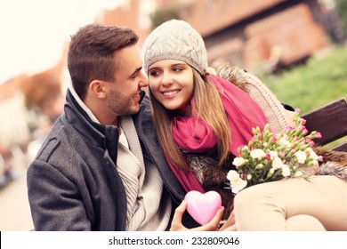 Foto de una pareja en el Día de San Valentín en el parque con flores y corazón