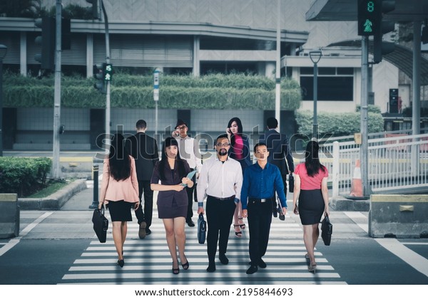 Picture of crowded business people looks busy while\
crossing the road