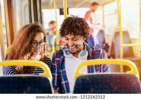 Picture of cute young mix race couple sitting in a bus and talking.