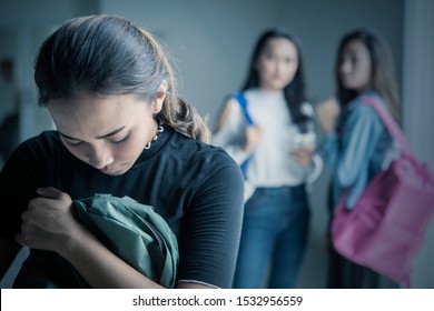 Picture of depressed teenage girl bullied with her friends in the classroom