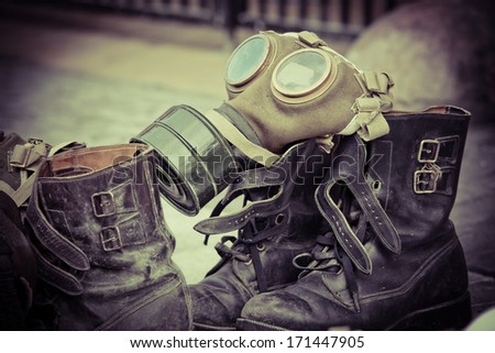 Picture of dirty old used boots and a gasmask 