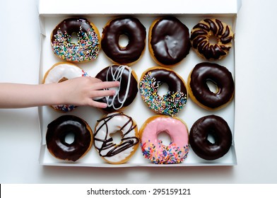 Picture Of Doughnut Box With A Child's Hand Grabbing A Doughnut