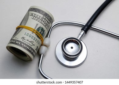 A Picture Of Fake Money With Stethoscope. Medical Bill In Private Hospital Keep On Increase Every Year And The Doctor Want The Consultation Fee Increase.