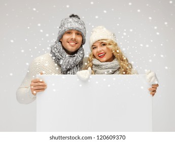 Picture Of Family Couple In A Winter Clothes Holding Blank Board