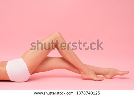 Picture of female, long legs isolated on pink background.