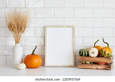 Picture frame mockup with wooden box of decorative pumpkins, vase of dry wheat on white table in nordic room interior. - Powered by Shutterstock