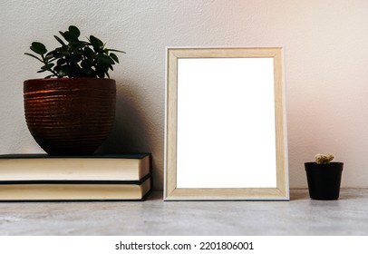 A Picture Frame Placed On A Book With A Small Plant Pot