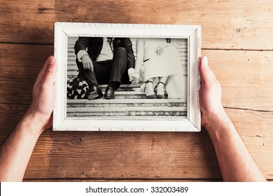 Picture Frame With Wedding Photo. Studio Shot On Wooden Background.