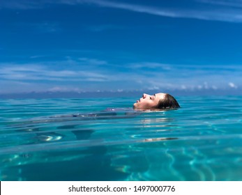 Picture of girl enjoying summer vacation in Varadero, Cuba, resting and floating on crystal clear water.