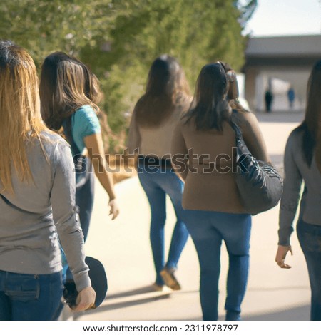 A picture of a group of university students carrying bags and going to the university in preparation for the new semester