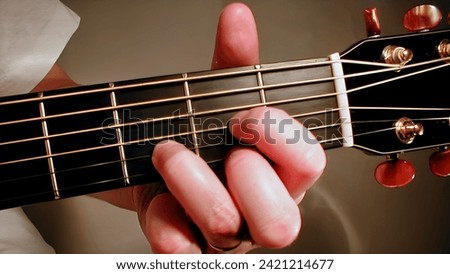 a picture of a hand making a D Chord on a guitar fret board. This photograph shows an up close view of  the correct hand position for making the D chord.