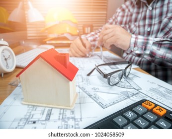 Picture of handsome male engineer,architect man working with computer and blueprints documents on desk inspection in workplace for architectural plan,sketching a construction project,selective focus.