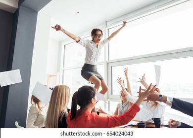 Picture Of Happy Business Team Celebrating Victory In Office. Woman Stand On Table