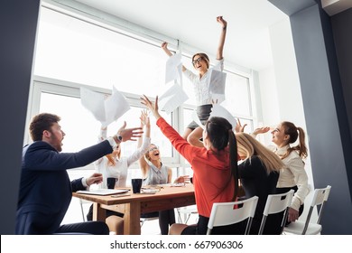 Picture Of Happy Business Team Celebrating Victory In Office. Woman Stand On Table